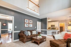 Luxurious living room with brown sofas, coffee table, and open kitchen layout.